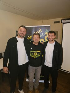 Andreas Klement mit den verletzten Eintracht-Hagen-Spielern Max Öhler und Tim Düren beim Krombacher FanTalk zum Spiel in Dessau.