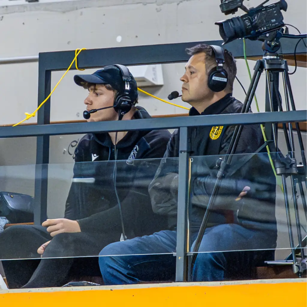 Andreas Klement als Handball TV-Kommentator mit Headset auf der Tribüne während einer Liveübertragung